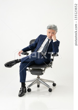 A businessman sitting in a chair A businessman sitting in a chair 133123652