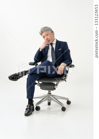 A businessman sitting in a chair A businessman sitting in a chair 133123653