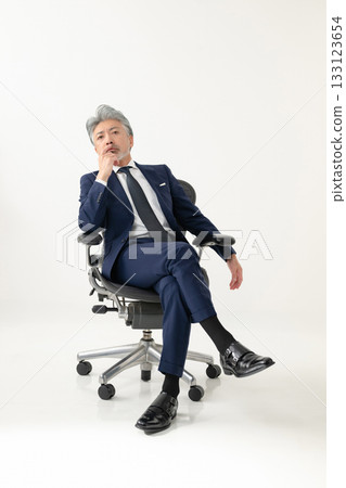 A businessman sitting in a chair 133123654