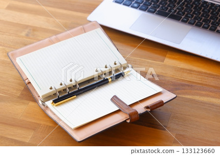 Image of a ring-type system organizer open while doing desk work 133123660