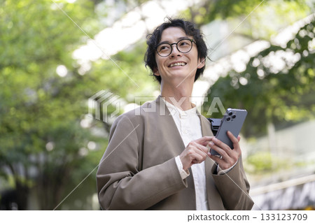 一名三十多歲的男子拿著智慧型手機 133123709