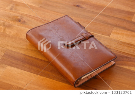Image of doing desk work with a brown leather notebook Image of doing desk work with a brown leather notebook 133123761