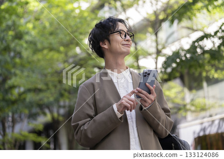 一個三十多歲的男人用智能手機 133124086