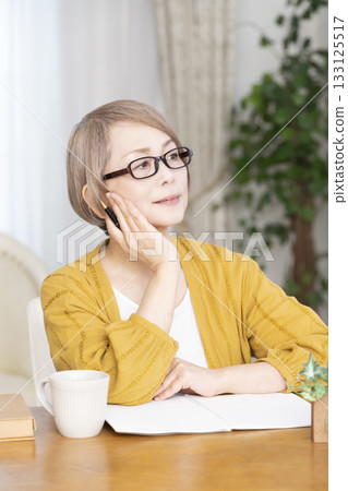 Senior woman writing an end-of-life note in the living room Senior woman writing an end-of-life note in the living room 133125517