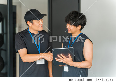 Sports gym, trainer in training gym, male instructor staff Sports gym, trainer in training gym, male instructor staff 133125754