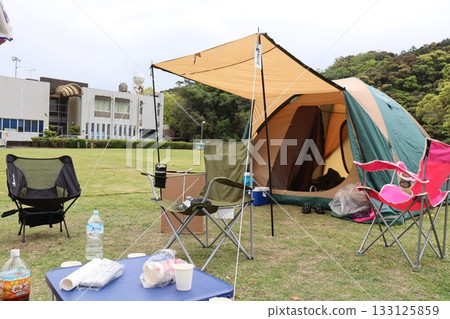A warm outdoor scene with a tent — a casual camping scene near the city A warm outdoor scene with a tent — a casual camping scene near the city 133125859