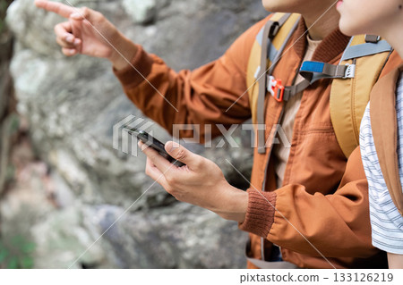 Navigating Nature Trails. Young man using smartphone for directions. 133126219