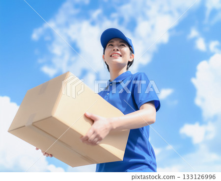 Female delivery staff carrying packages under the blue sky Female delivery staff carrying packages under the blue sky 133126996
