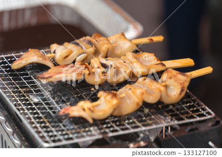 Grilled squid being cooked at a food stall Grilled squid being cooked at a food stall 133127100