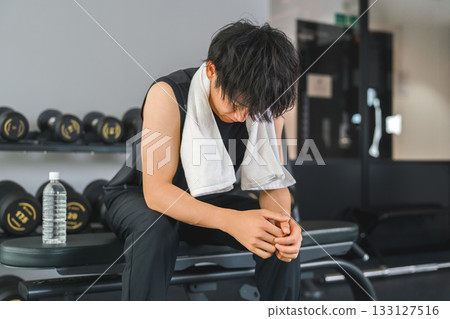 健身房，一位年輕的亞洲男子正在休息。 133127516