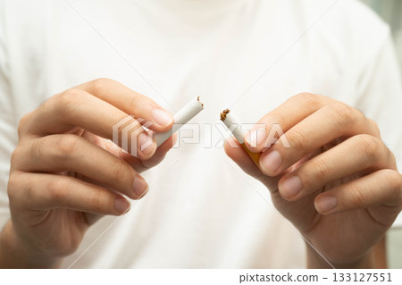 Quit smoking, Asian teenage man breaking destroy cigarette in hand. 133127551