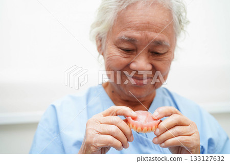 Doctor holding teeth denture in hand for dentist studying about dentistry. 133127632