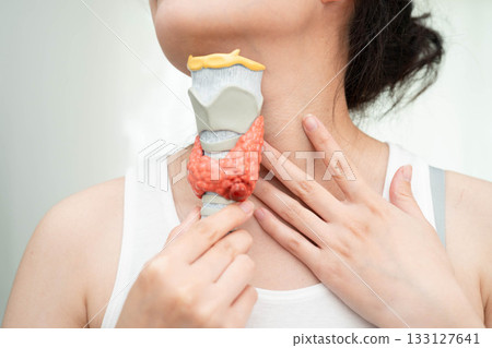 Hyperthyroidism, Overactive Thyroid, Thyroid Lymphoma, Asian woman with thyroid gland human anatomy model. 133127641