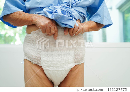 Asian senior woman patient wearing adult incontinence diaper pad in hospital. Asian senior woman patient wearing adult incontinence diaper pad in hospital. 133127775