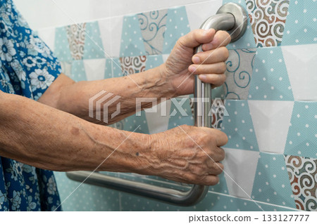 Asian elderly woman use safety handrail in bathroom. 133127777