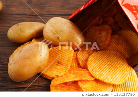 Potato chips in open bag, delicious BBQ seasoning spicy for crips, thin slice deep fried snack fast food. Potato chips in open bag, delicious BBQ seasoning spicy for crips, thin slice deep fried snack fast food. 133127780