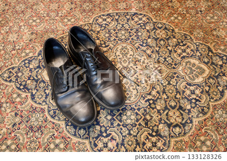 Leather shoes on typical and classical oriental carpet 133128326