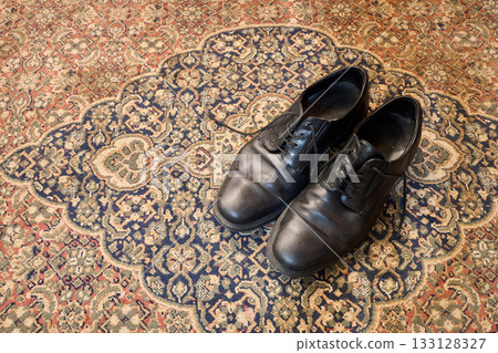 Leather shoes on typical and classical oriental carpet 133128327