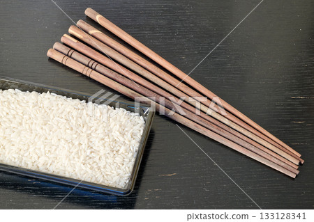 Rice, greek pasta and chopstick on black board 133128341