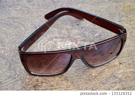 Sunglasses in close up on wooden garden chair 133128352