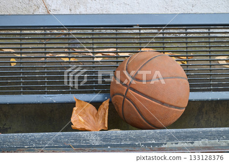 Well used basket ball on ground 133128376