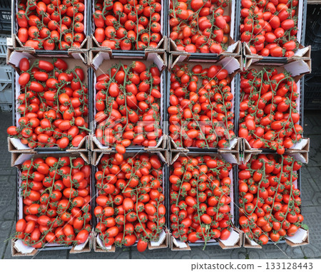 Cherry tomatoes in boxes at street market. Vegetables and farm produce. 133128443
