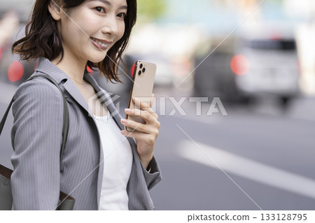 Hand of a business woman with a smartphone 133128795