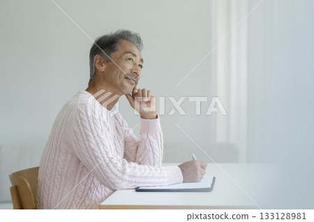 Senior man writing with a pen 133128981