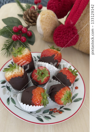 Chocolate-covered strawberries on ceramic saucer. Christmas dessert. Holidays and decorations, food. Chocolate-covered strawberries on ceramic saucer. Christmas dessert. Holidays and decorations, food. 133129142