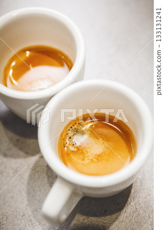 Two Cups of Freshly Brewed Espresso on Countertop, Showcasing Rich Crema and Warm Colors Two Cups of Freshly Brewed Espresso on Countertop, Showcasing Rich Crema and Warm Colors 133131241