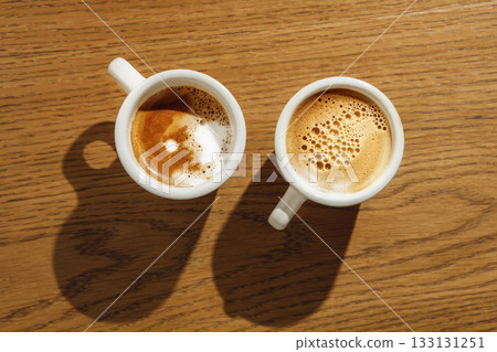 Two White Cappuccino Cups Brewed Beautifully on Wooden Table From Top View 133131251