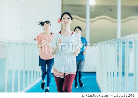 Men and women running on an indoor track Men and women running on an indoor track 133132241
