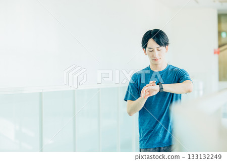 A man exercising while keeping an eye on his time A man exercising while keeping an eye on his time 133132249