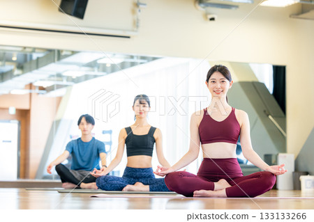 Young men and women practicing yoga in a yoga studio Young men and women practicing yoga in a yoga studio 133133266