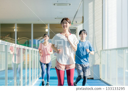 Men and women running on an indoor track Men and women running on an indoor track 133133295