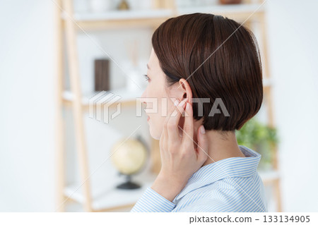 Woman touching her ear (hearing) 133134905