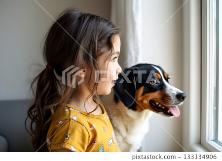 Child and dog looking out the window on a sunny afternoon, sharing a moment of curiosity and connection 133134906