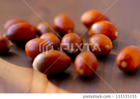 Acorns rolling on a wooden table 133135155