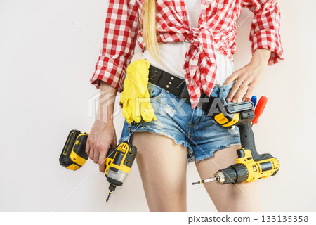 Woman with toolbelt and drill 133135358