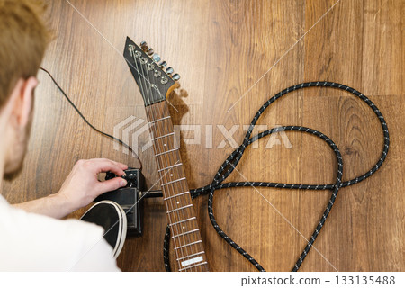 Man adjusting guitar effects pedal Man adjusting guitar effects pedal 133135488