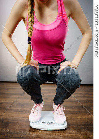 Teenage woman on bathroom scale machine Teenage woman on bathroom scale machine 133135710