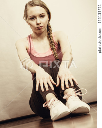 Sad depressed young teenage girl sitting by wall Sad depressed young teenage girl sitting by wall 133135711
