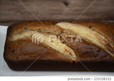 Freshly baked banana bread with golden crust served on a plate Freshly baked banana bread with golden crust served on a plate 133136312