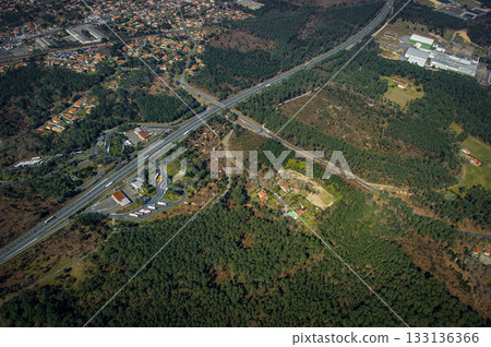 Trucks parked near highway and service area in forested setting Trucks parked near highway and service area in forested setting 133136366