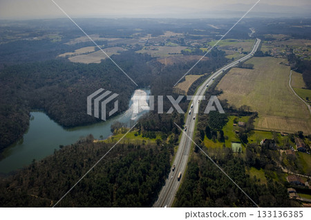 Scenic highway view near a lake and fields in rural landscape 133136385