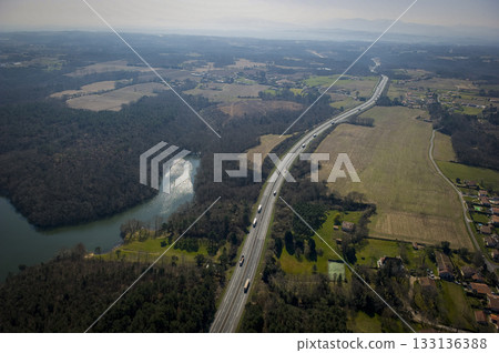 Scenic highway view near a lake and fields in rural landscape 133136388