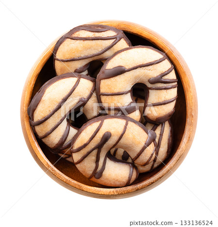 Crescent shaped shortbread cookies, in a wooden bowl. Crumbly biscuits, made from high ratio of butter, along with sugar and flour, partially glazed with chocolate, chocolate dipped at the bottom. Crescent shaped shortbread cookies, in a wooden bowl. Crumbly biscuits, made from high ratio of butter, along with sugar and flour, partially glazed with chocolate, chocolate dipped at the bottom. 133136524