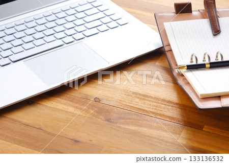 Image of a ring-type system organizer open and doing desk work on a laptop Image of a ring-type system organizer open and doing desk work on a laptop 133136532