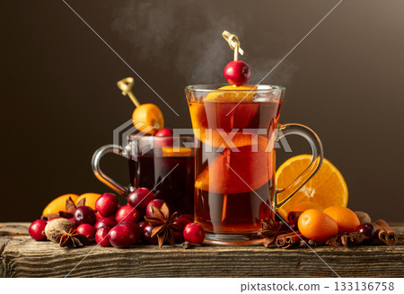 Winter drinks with spices, cranberries, and citrus fruits on a dark background. Winter drinks with spices, cranberries, and citrus fruits on a dark background. 133136758