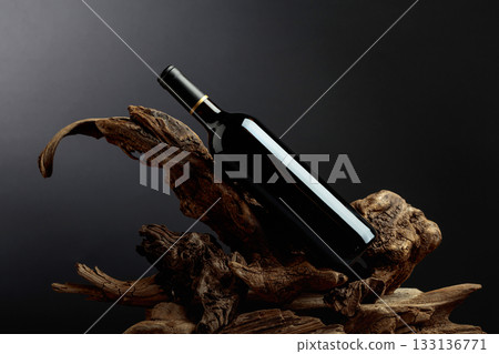Bottle of red wine on a old snags. 133136771